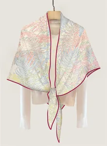 Close-up of winter scarf with floral jungle pattern and contrast edge on white shirt