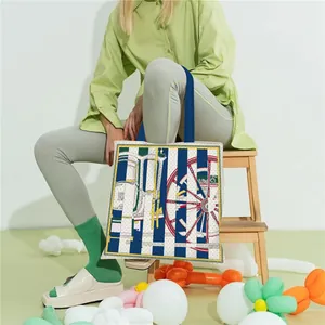 Detail of canvas tote bag with horse harness prints and blue stripes in a lifestyle scene