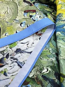 Gros plan du foulard imprimé Van Gogh montrant la texture fine et la bordure en ruban bleu