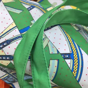 Detail of green canvas tote bag with multi-color fashion prints and sturdy handle stitching