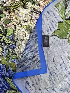 Detail of 100% silk scarf showing fine floral print and navy blue hand-rolled edges