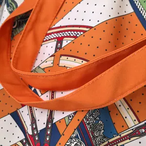 Close-up of orange fabric handle and luxury pattern stitching on large canvas tote bag