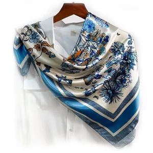 Close-up of floral butterfly pattern on silky square scarf draped on white shirt