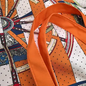 Detail of orange woven handles and bohemian geometric print on large canvas tote bag