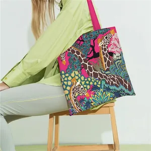 Pink canvas tote bag with giraffe floral print and hot pink straps in a lifestyle scene