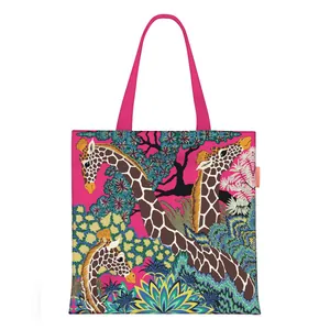 Detail of pink canvas tote bag featuring giraffe and tropical plant art illustration