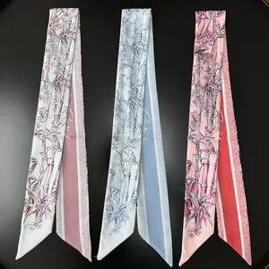 Three silk scarves with bamboo and floral prints in pink, blue, and red on black