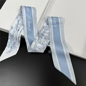 Elegant bamboo floral silk scarf with Paris lettering draped over a white gift box