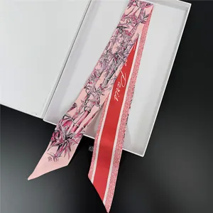 Detail of silk twilly scarf with pink floral bamboo print and red Paris logo side