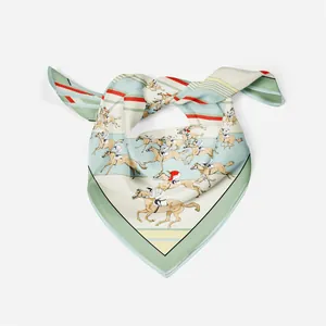 Détail d'un foulard en soie noué avec imprimé équestre en vert menthe et beige