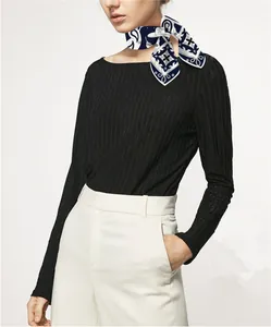 Detail of blue and white paisley silk scarf with hand-rolled edges on female model