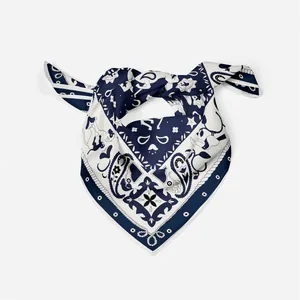 Detail of navy blue twill silk square scarf featuring tropical bird and paisley patterns