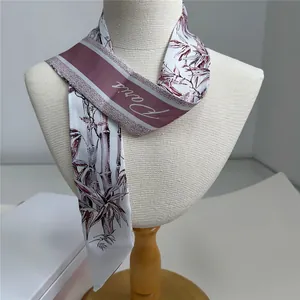 Detail showing smooth silk ribbon scarf with purple bamboo print and Paris lettering