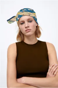 Détail d'un foulard en soie à imprimé équestre porté comme un bandeau vintage