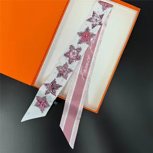 Elegant pentagram and floral print silk twilly scarf displayed in a classic orange box
