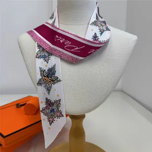 Detail of silk twilly scarf with pink floral and butterfly patterns tied on a mannequin
