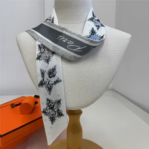 Detail of floral butterfly twilly scarf with Paris text worn on a mannequin neck