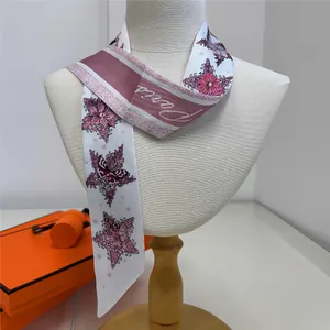 Close-up of silk twilly scarf with floral butterfly print and Paris text detail