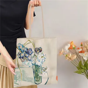 Sac cabas en toile avec imprimé floral artistique et longues anses porté par un modèle