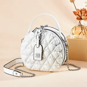White quilted circular shoulder bag with silver chain strap and top handle design