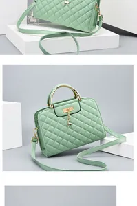 Detail of mint green quilted handbag featuring golden metal handles and a deer charm