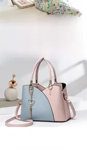 Dettaglio borsa bicolore rosa e blu con ciondolo a cuore e rifiniture in metallo oro