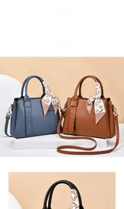 Detail showing litchi grain faux leather handbag with crocodile pattern strap and scarf