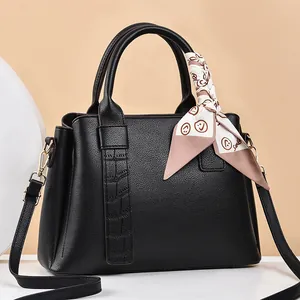 Large black pebbled leather handbag with crocodile pattern strap and smile silk scarf