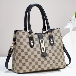 Gros plan détaillé du sac cabas tissé beige avec poignées noires et boucle en métal doré