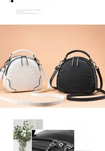 Detail of crocodile-textured leather on shell-shaped crossbody bags with silver zippers