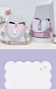 Detail view of stylish gradient bucket bag featuring floral textures and embroidered strap