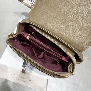 Vue intérieure d'un sac à main en cuir marron avec compartiments et doublure rouge