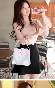 Close-up of lifestyle scene showing gradient bucket bag with floral patterns and white handle