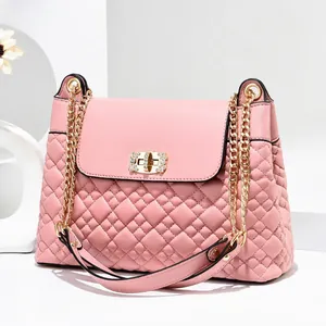 Pink quilted crossbody bag with gold chain strap and sparkling rhinestone twist lock detail