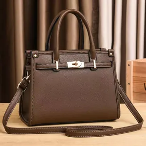 Brown leather Kelly handbag with golden hardware shown in a high-quality studio setting