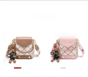 Detailed view of mini crossbody phone bags in coffee and pink with plaid rabbit charms