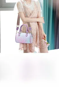 Close-up of a gradient purple Boston bag with floral print and wide woven VENUS strap