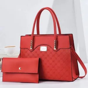 Vue détaillée du sac à main rouge avec motif rose gaufré et portefeuille assorti