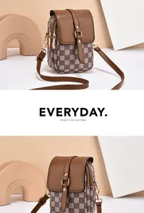 Detailed view of vintage plaid crossbody phone bag with brown leather flap and gold buckle