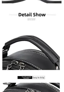 Close-up of black leather handbag with white contrast stitching and round top handle