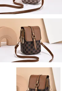 Detail view of multi-layer zipper pockets and checkered print on mini leather phone bag