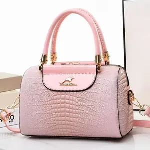 Close-up of pink bucket bag with crocodile texture and shiny patent leather detail