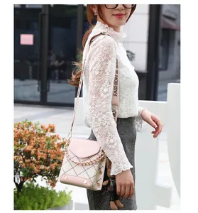 Detail of pink crossbody bag with quilted pattern, wide strap and cute rabbit pendant