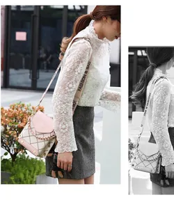 Detail of pink quilted mini crossbody bag with wide logo strap and bear charm