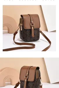 Detail view of brown monogram JVZD crossbody bag with dual zippers and gold hardware
