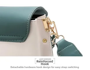 Detail of reinforced gold metal hooks and detachable wide strap on contrast shoulder bag
