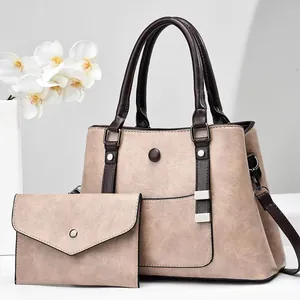 Detail of beige faux leather tote with lychee grain, matching clutch and orchid decor