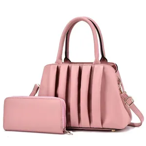Close-up of pink pleated tote bag and matching long wallet with adjustable metal buckle strap