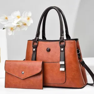 Three-piece retro brown leather tote set with crossbody strap and envelope clutch bag