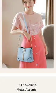 Detail of light blue crossbody bag featuring gold cat hardware and fringe tassel detail